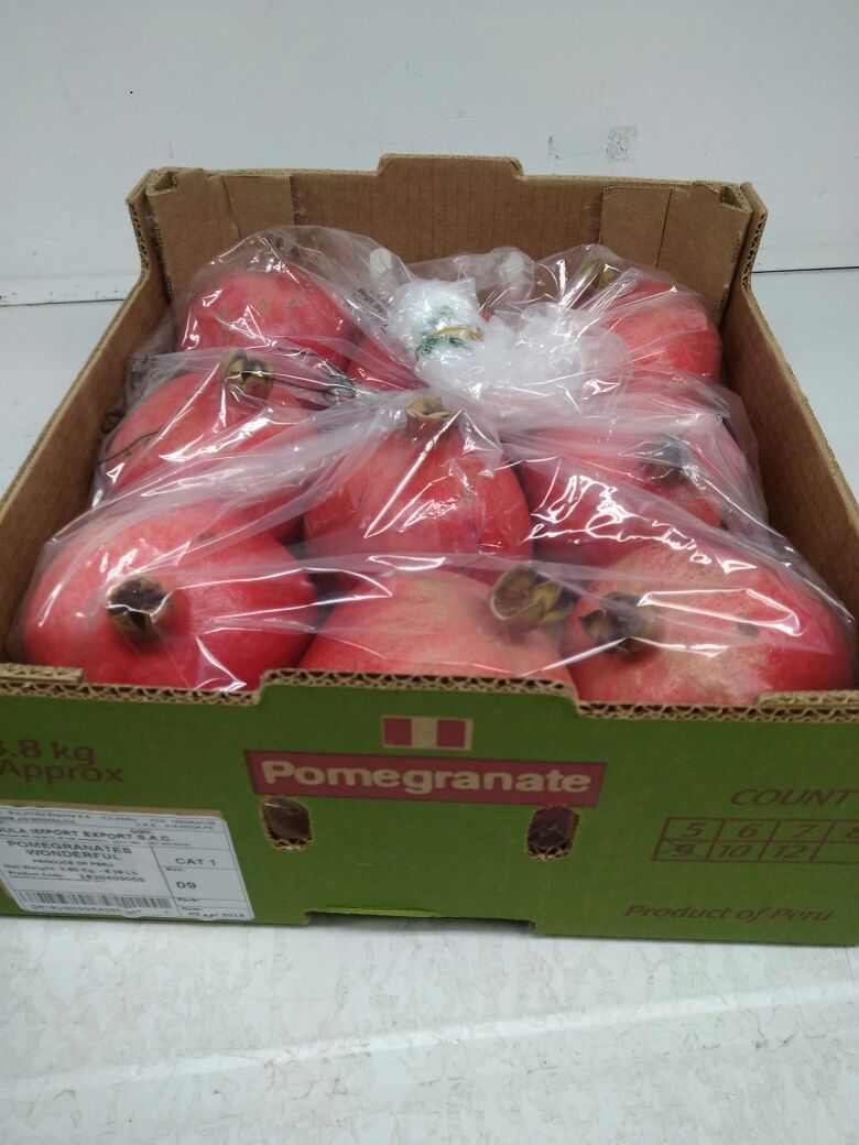La fruta posee una piel gruesa de color escarlata o dorada con tono carmesí en el exterior y una gran cantidad de semillas internas rodeadas de una jugosa